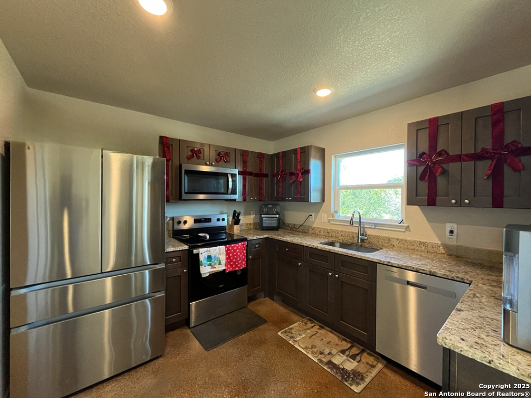 2708 Golf Drive Spring Branch, TX 78070 - Photo 8 of 31 a kitchen with stainless steel appliances granite countertop a refrigerator and a sink