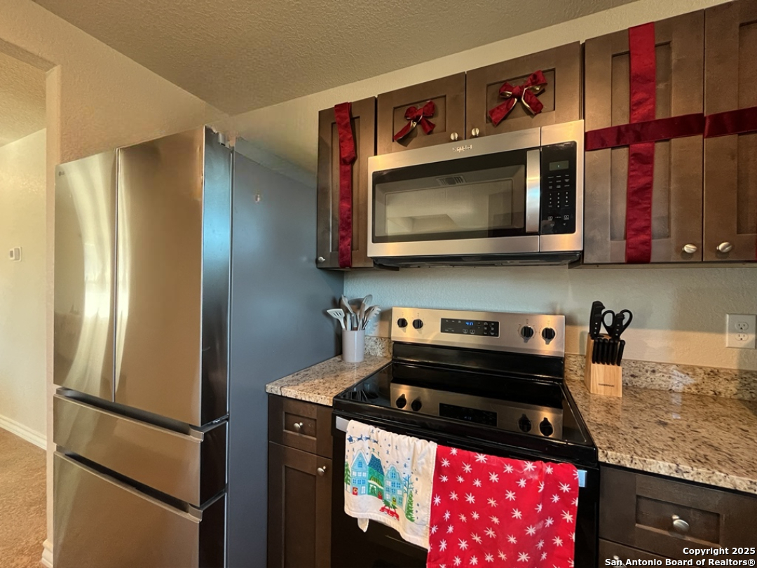 2708 Golf Drive Spring Branch, TX 78070 - Photo 9 of 31 a kitchen with stainless steel appliances granite countertop a stove a microwave and a refrigerator