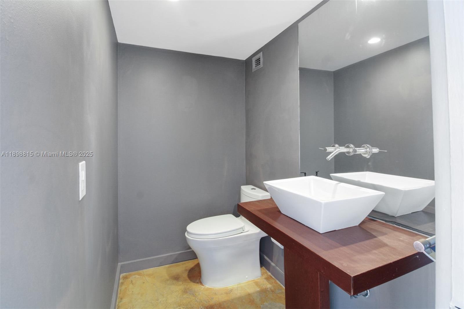 5 Island Avenue, Unit 4E Miami Beach, FL 33139 - Photo 23 of 23 a bathroom with a toilet a sink and mirror