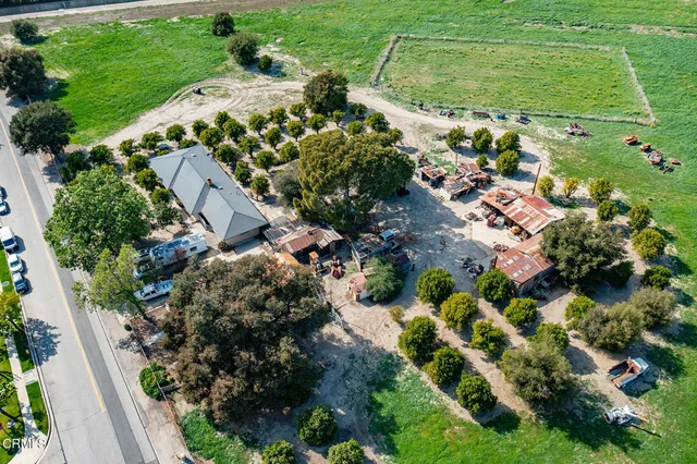 an aerial view of residential houses with outdoor space and trees