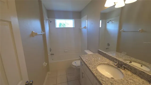 a bathroom with a granite countertop sink a mirror and shower