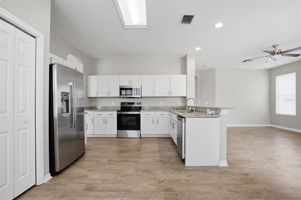 27001 Arrowbrook Way Wesley Chapel, FL 33544 - Photo 13 of 44 a kitchen with white cabinets and stainless steel appliances