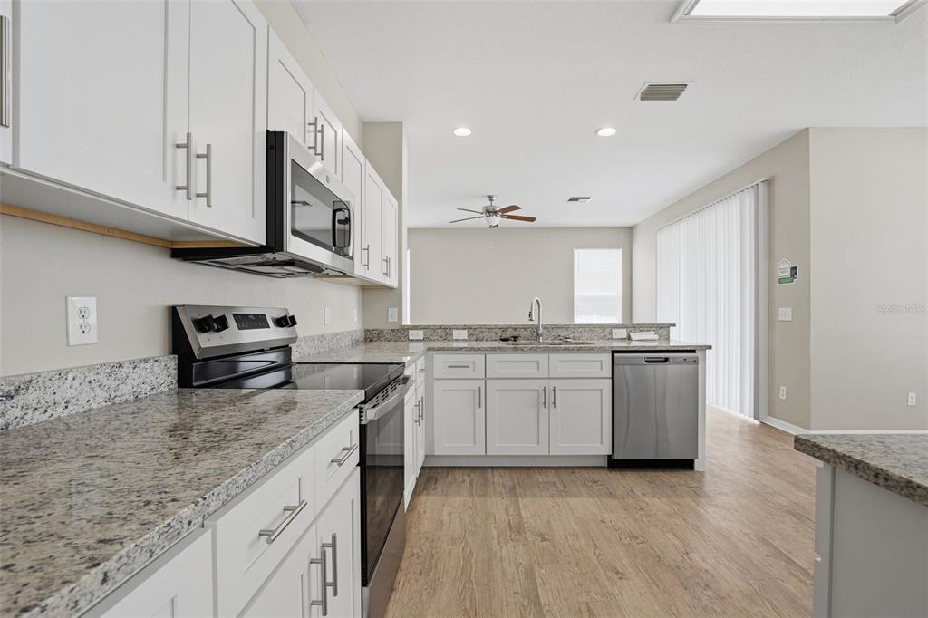27001 Arrowbrook Way Wesley Chapel, FL 33544 - Photo 16 of 44 a kitchen with granite countertop a sink and a stove top oven