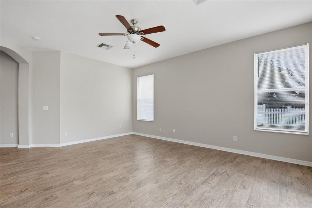 27001 Arrowbrook Way Wesley Chapel, FL 33544 - Photo 23 of 44 an empty room with wooden floor fan and windows