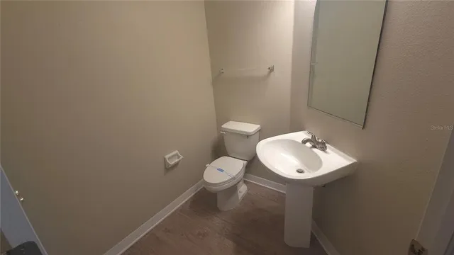 a bathroom with a toilet a sink and mirror