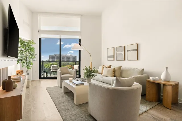 a living room with furniture a large window and a flat screen tv