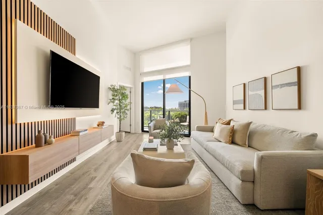 a living room with furniture two large windows and a potted plant