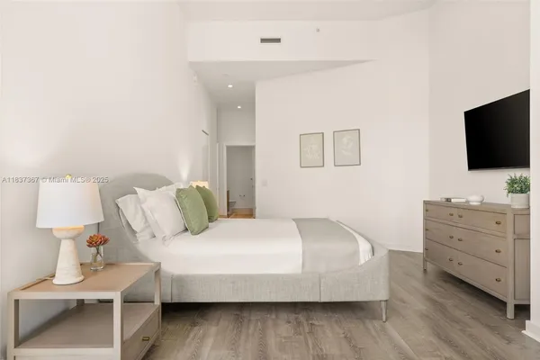 a bedroom with a bed and a flat screen tv