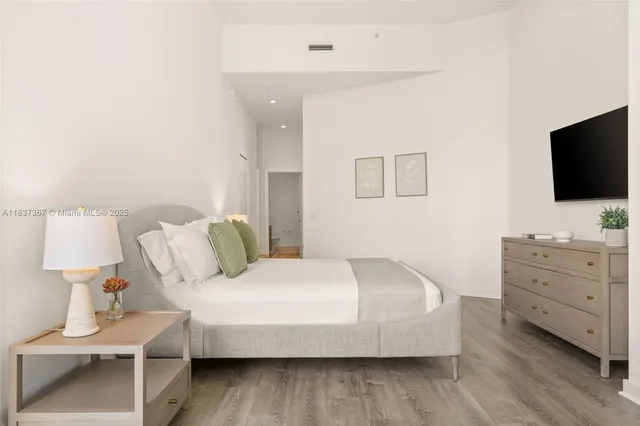 a bedroom with a bed and a flat screen tv