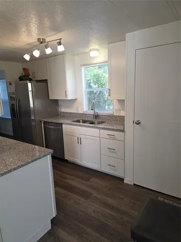 a kitchen with a sink a window and stainless steel appliances