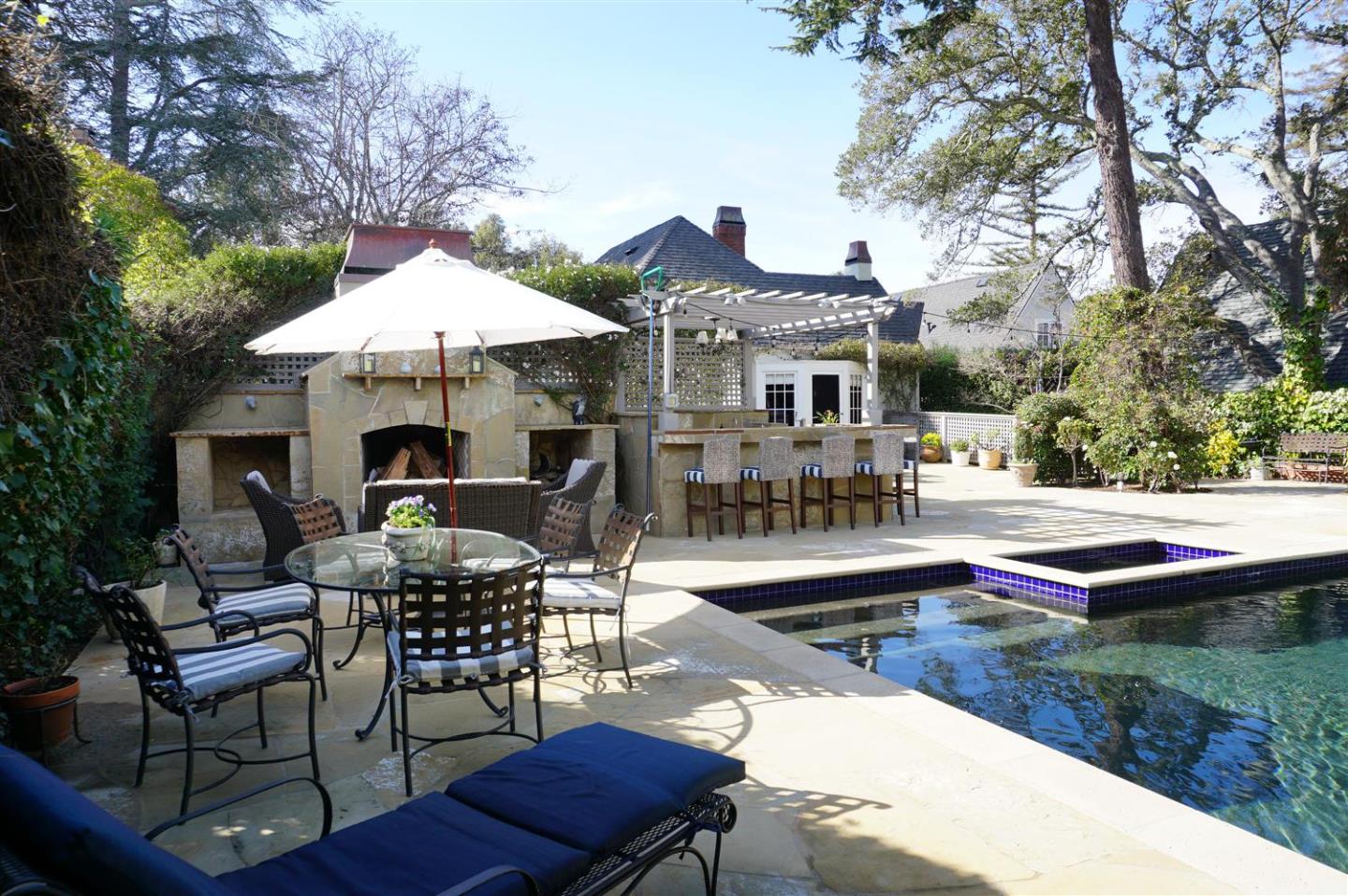 440 Edgewood Road San Mateo, CA 94402 - Photo 37 of 39 a patio with a table and chairs under an umbrella