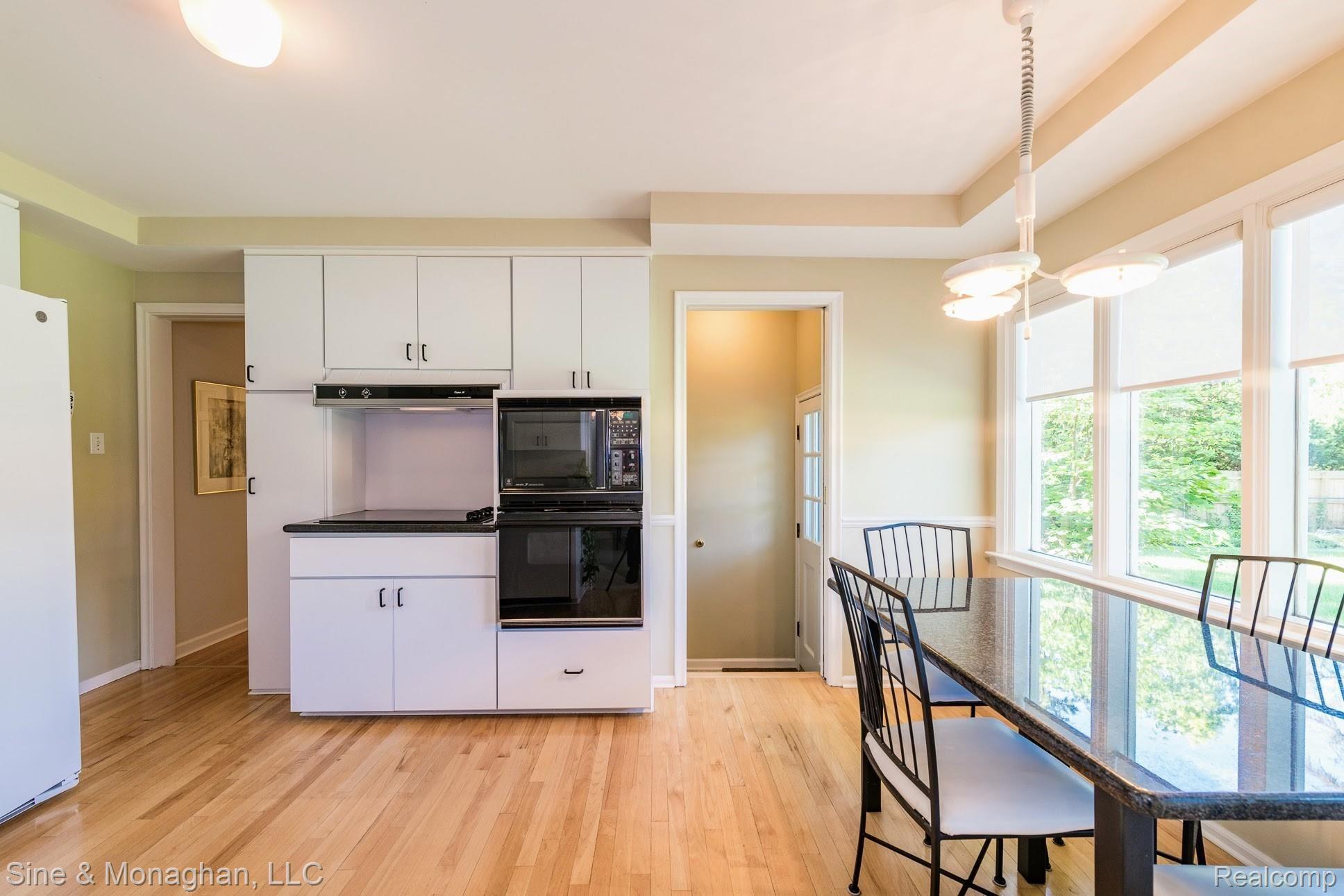 336 South Cranbrook Cross Road Bloomfield Hills, MI 48301 - Photo 15 of 40 Kitchen with wood floor, dining space and rear yard view