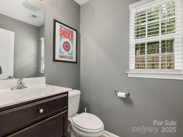 a bathroom with a sink a toilet and a window