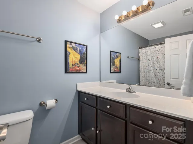 a bathroom with a sink vanity mirror and toilet