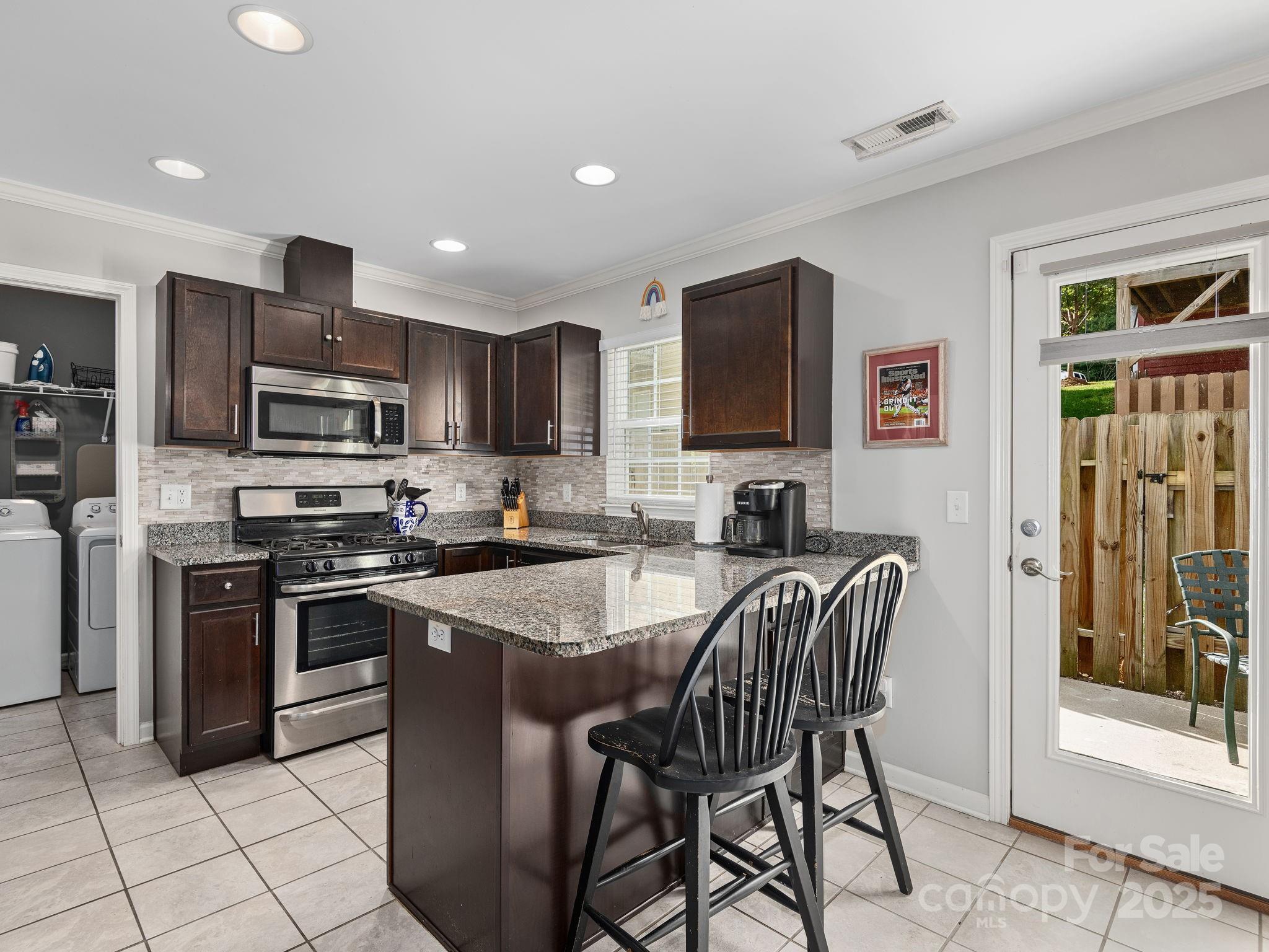 158 Alpine Ridge Drive Asheville, NC 28803 - Photo 6 of 18 a kitchen with stainless steel appliances granite countertop a stove top oven a sink dishwasher a dining table and chairs