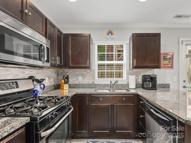 a kitchen with granite countertop a stove sink and cabinets