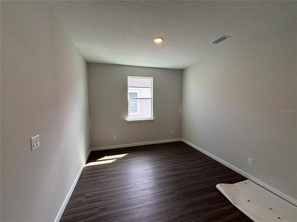 63 Pegasus Road Flagler Beach, FL 32136 - Photo 11 of 35 an empty room with wooden floor and windows