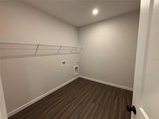 a view of a room with wooden floor and a ceiling fan
