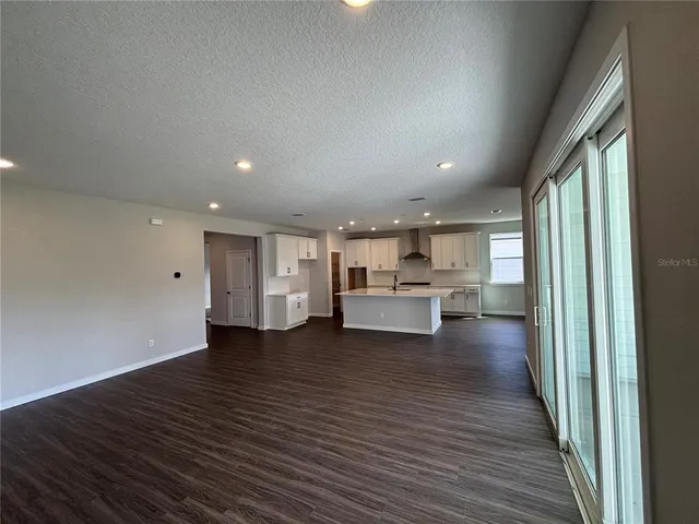 a large kitchen with stainless steel appliances a large counter top a stove and a refrigerator