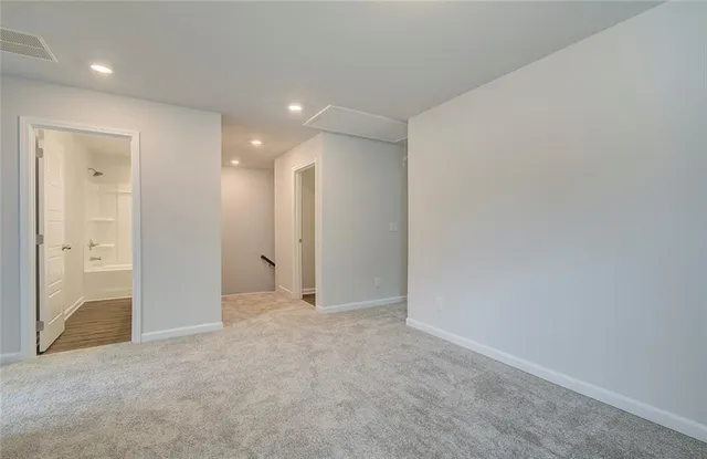 an empty room with closet and a bathroom