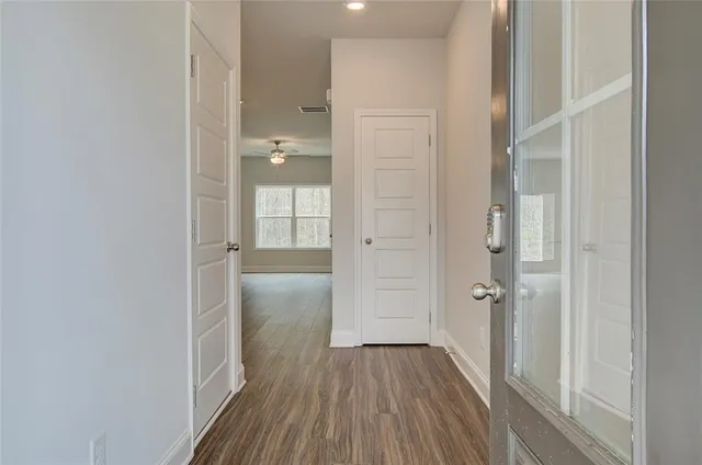 a view of a hallway with wooden floor and closet area