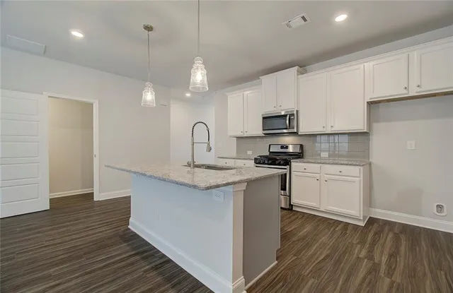 a kitchen with granite countertop a stove and a sink
