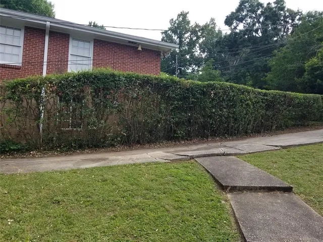 a backyard of a house with table and chairs a barbeque with potted plants
