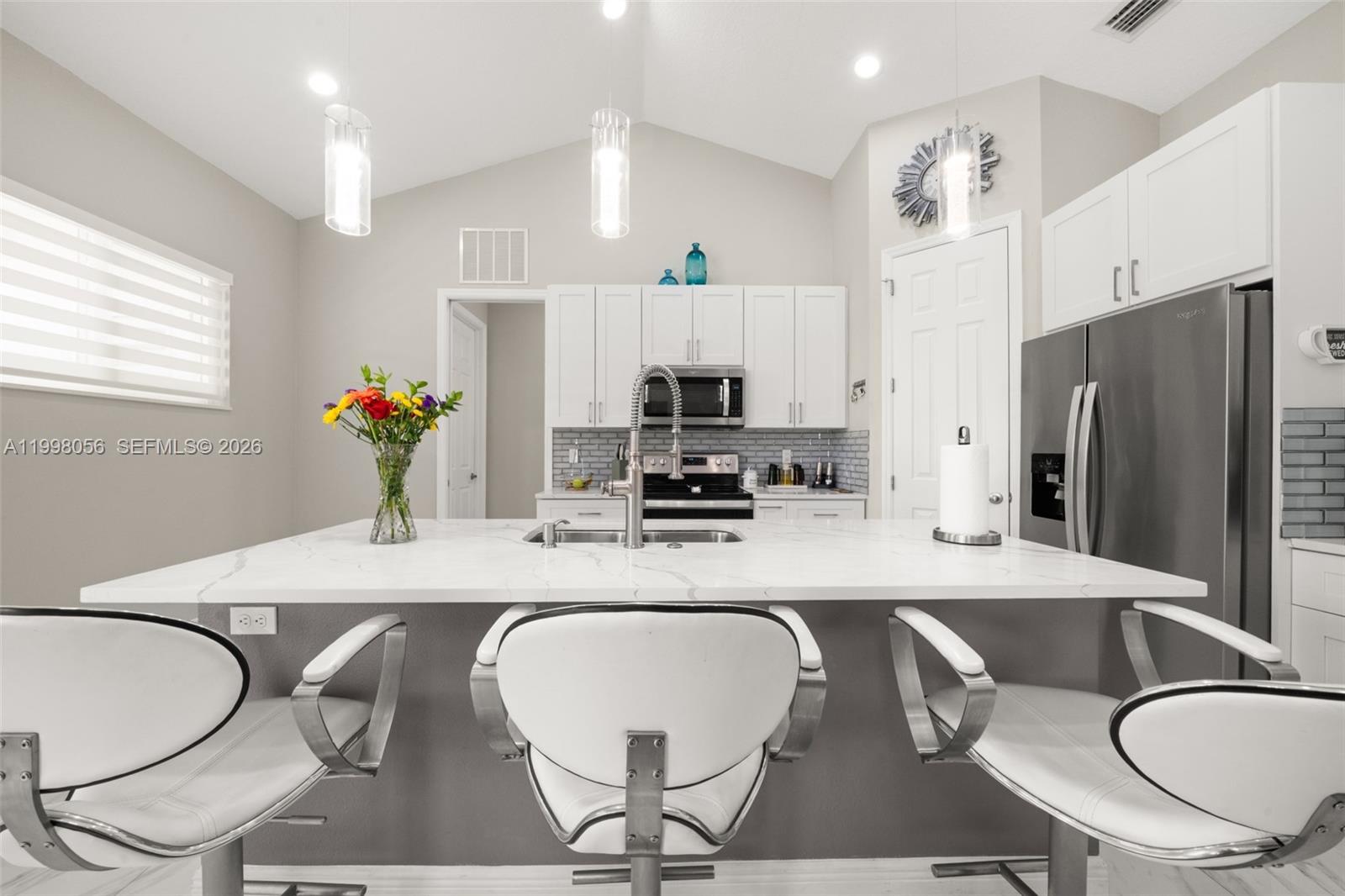 2009 Flower Sebring, FL 33875 - Photo 9 of 61 a kitchen with granite countertop a dining table chairs and a refrigerator