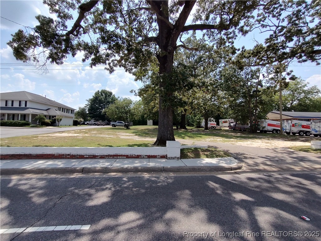 a view of a house with a big yard and large trees