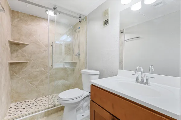 a bathroom with a sink a toilet and shower