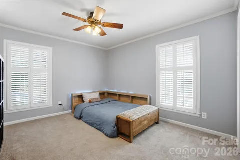 a bedroom with a bed and a large window
