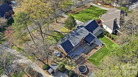 a aerial view of a house with a yard and large trees