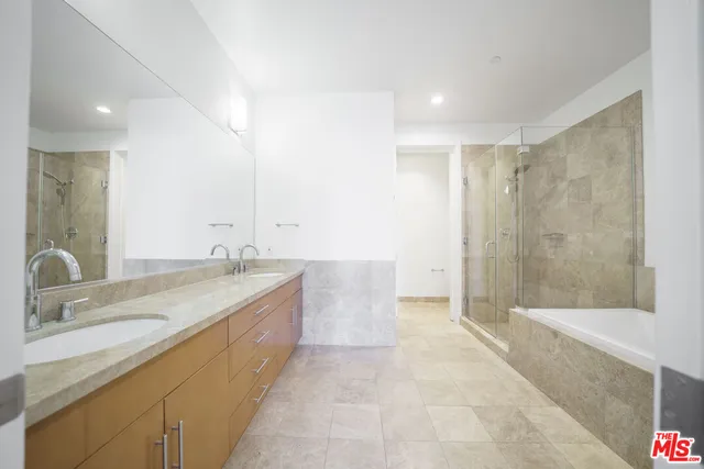 a bathroom with a granite countertop sink a toilet a mirror and bathtub