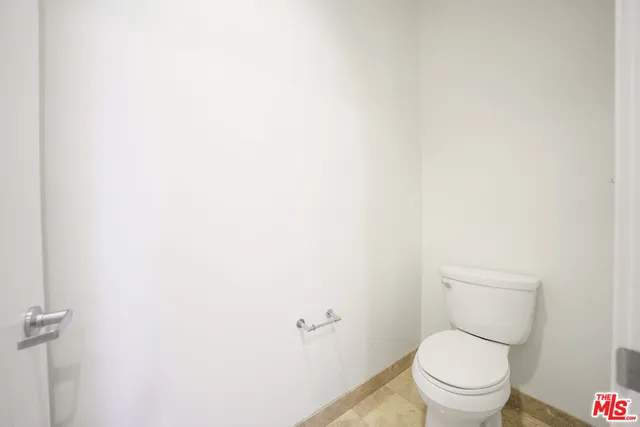 a white toilet sitting next to a white wall