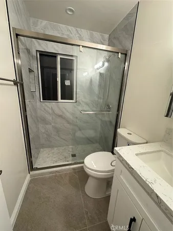 a bathroom with a granite countertop sink toilet and shower