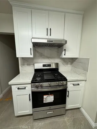 a stove top oven sitting inside of a kitchen