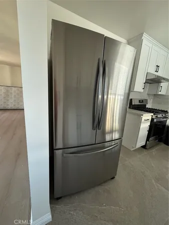 a metallic refrigerator freezer sitting in a kitchen