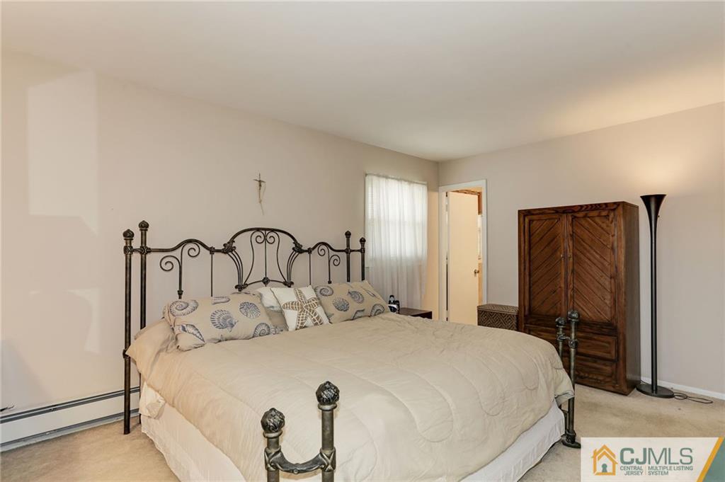 653 Lloyd Road Aberdeen, NJ 07747 - Photo 13 of 18 a bedroom with a bed and a large mirror