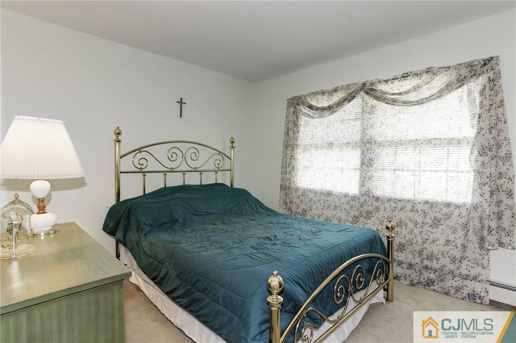 653 Lloyd Road Aberdeen, NJ 07747 - Photo 14 of 18 a bedroom with a bed and a window
