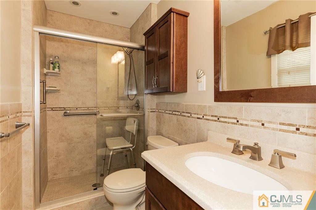 653 Lloyd Road Aberdeen, NJ 07747 - Photo 16 of 18 a bathroom with a sink toilet and shower