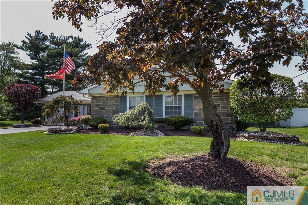 653 Lloyd Road Aberdeen, NJ 07747 - Photo 3 of 18 a front view of a house with a garden and trees