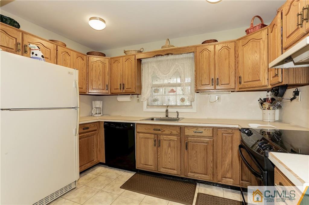 653 Lloyd Road Aberdeen, NJ 07747 - Photo 8 of 18 a kitchen with a sink a refrigerator and cabinets