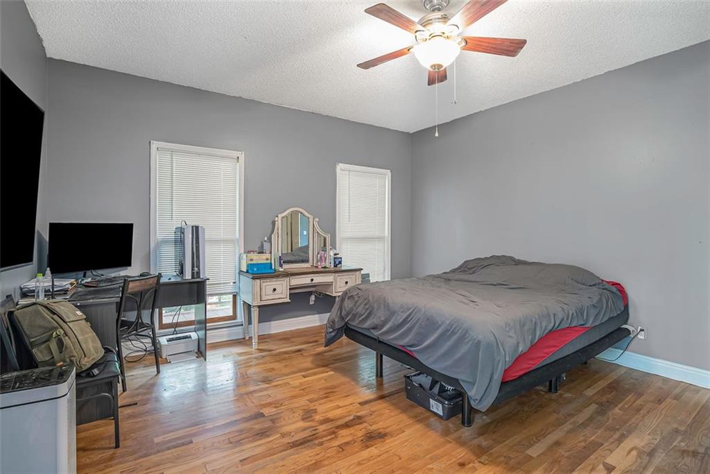 571 Runyon Road Cedartown, GA 30125 - Photo 1 of 1 a bedroom with a bed and a flat screen tv with wooden floor
