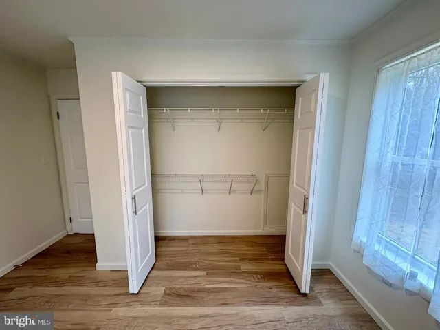 an empty room with wooden floor door and closet