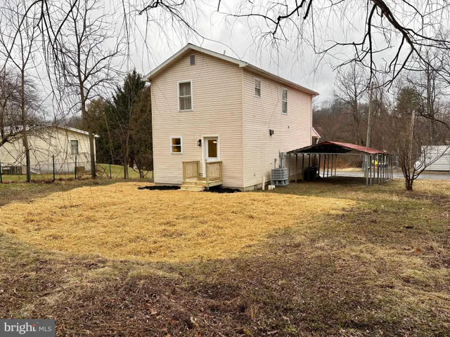 a view of a white house with a yard covered in snow