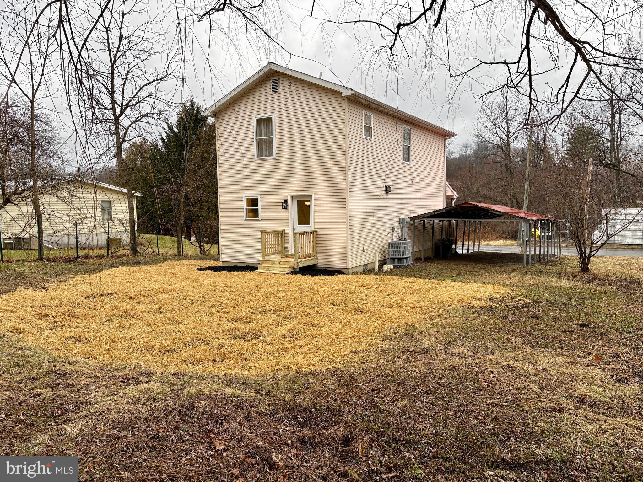 404 Front Street Port Matilda, PA 16870 - Photo 2 of 19 a view of a white house with a yard covered in snow