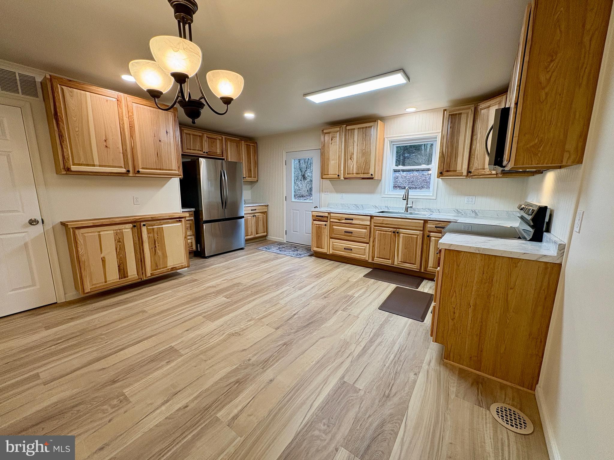 404 Front Street Port Matilda, PA 16870 - Photo 6 of 19 a large kitchen with stainless steel appliances granite countertop a lot of counter space and wooden floors