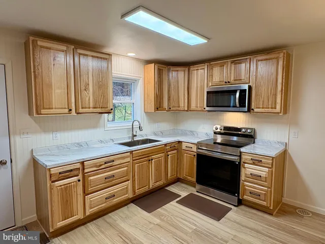 a kitchen with stainless steel appliances granite countertop a stove microwave and sink