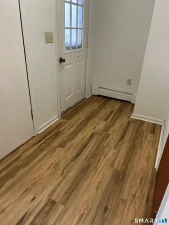 a view of empty room with wooden floor