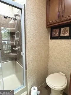 a bathroom with a toilet and a shower